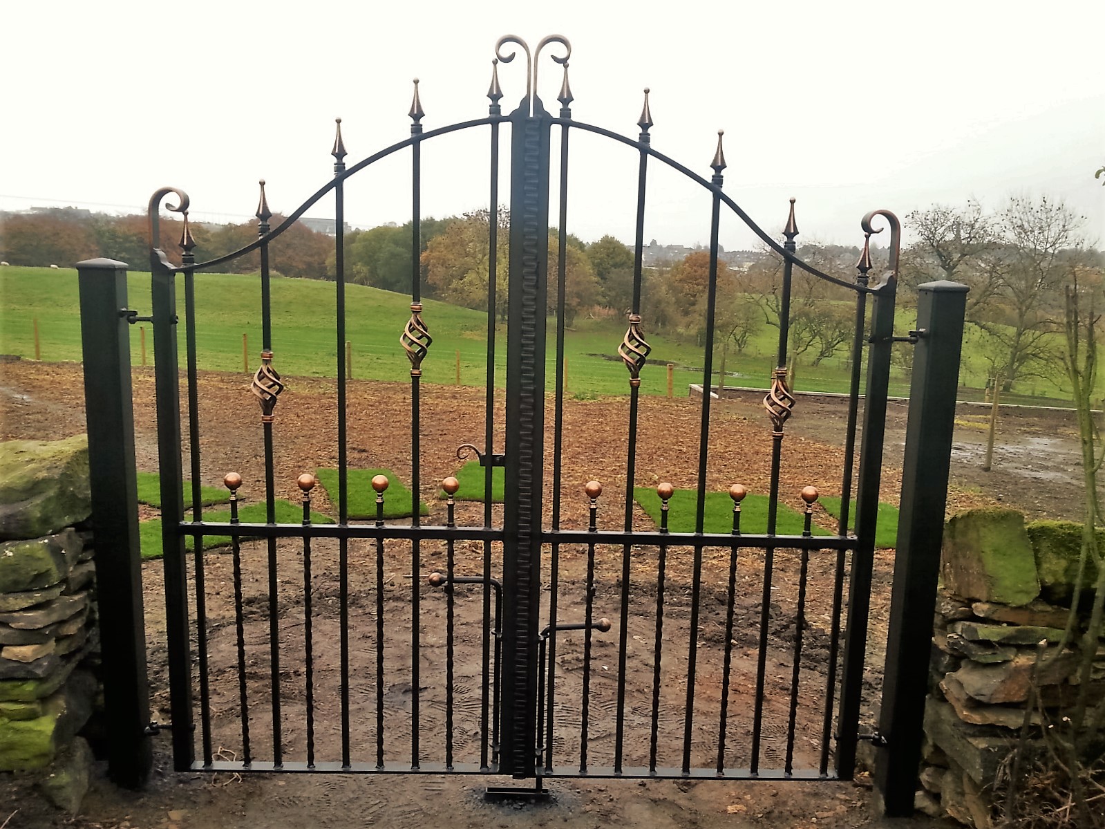 Wrought_iron_driveway_gates_copper_patina_bowtop